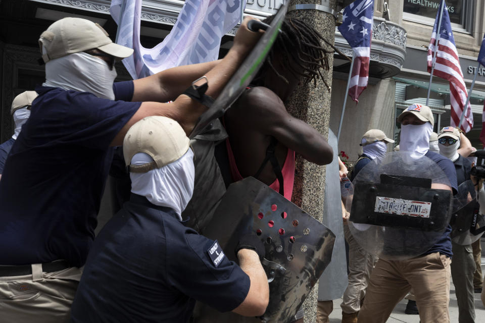 FILE - Members group bearing insignias of the white supremacist Patriot Front shove Charles Murrell with metal shields during a march through Boston on Saturday, July 2, 2022, in Boston. The Black musician who says members of the white nationalist hate group punched, kicked and beat him with metal shields during a march through Boston last year sued the organization on Tuesday, Aug. 8, 2023. (AP Photo/Michael Dwyer)