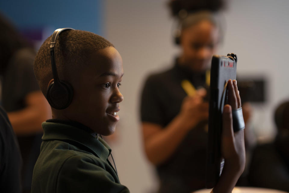 A student tries out "Unsung" a multiplayer AR experience that will allow kids to learn about four female icons of color through a "digital dollhouse." (Photo: Verizon Media). 