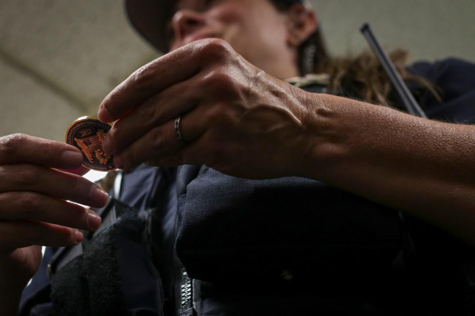 Officer Pratt holds a challenge coin she received after graduating from her police academy at the Salem Police Department on May 6, 2020. The coin was zipped into her vest when she was shot, and it's the first time she has held it since that day.