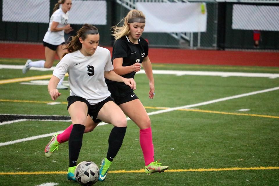 Isabelle Severns (left) shields the ball from Emma Grade during Saturday's Klahowya girls soccer alumni game played at Klahowya Secondary School. Klahowya's 2022 team edged the alumni team 4-3.