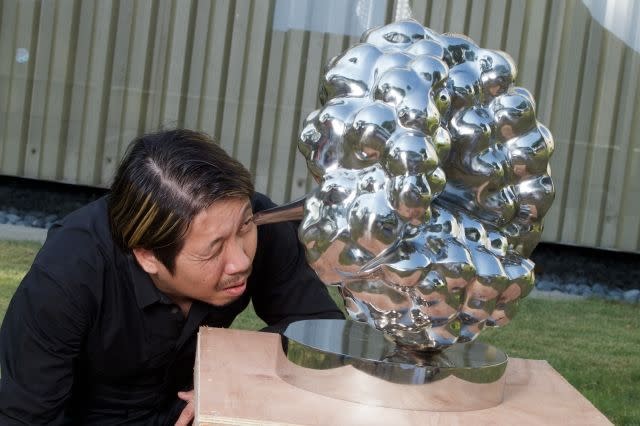 Artist Yeo Chee Kiong looking into a prototype of the SG50 commemorative sculpture "In the Eye of the Red Dot"