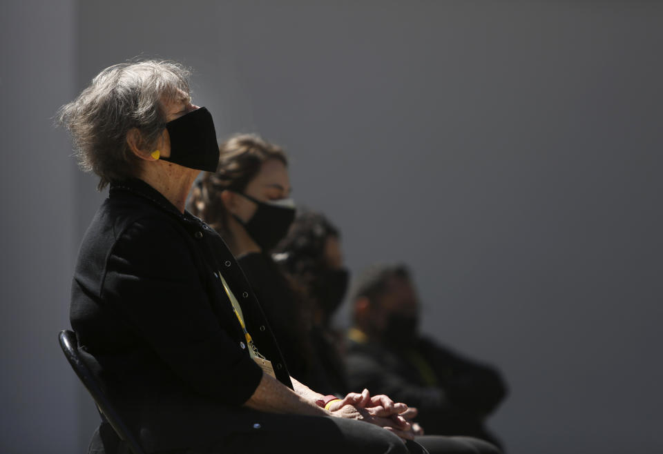 Peg Walter prays during the Queens COVID Remembrance Day event that she and her son helped organize, Saturday, May 1, 2021, to memorialize lives lost to the coronavirus in the Queens borough of New York. Walter's husband, John Walter, died from the virus May 10, 2020. (AP Photo/Jessie Wardarski)