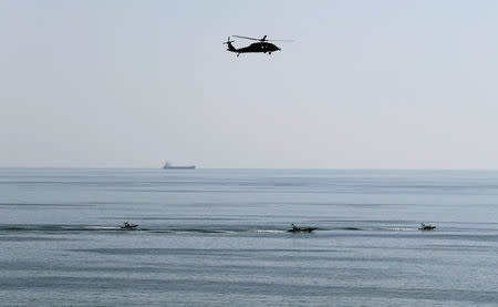 MH-60S helicopter hovers over Iranian Revolutionary Guards speed boats which are seen near the USS John C. Stennis CVN-74 as it makes its way to gulf through strait of Hormuz, December 21, 2018. REUTERS/Hamad I Mohammed