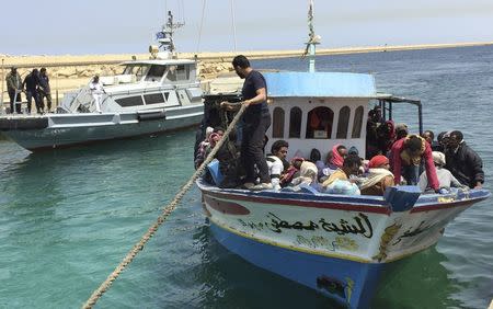 Illegal migrants who attempted to sail to Europe sit in a boat returning them to Libya as it is docked, after their boat was intercepted at sea by the Libyan coast guard, at Khoms, Libya May 6, 2015. REUTERS/Aymen Elsahli