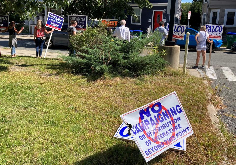 Volunteers comply with election law when they hold signs of support for candidates