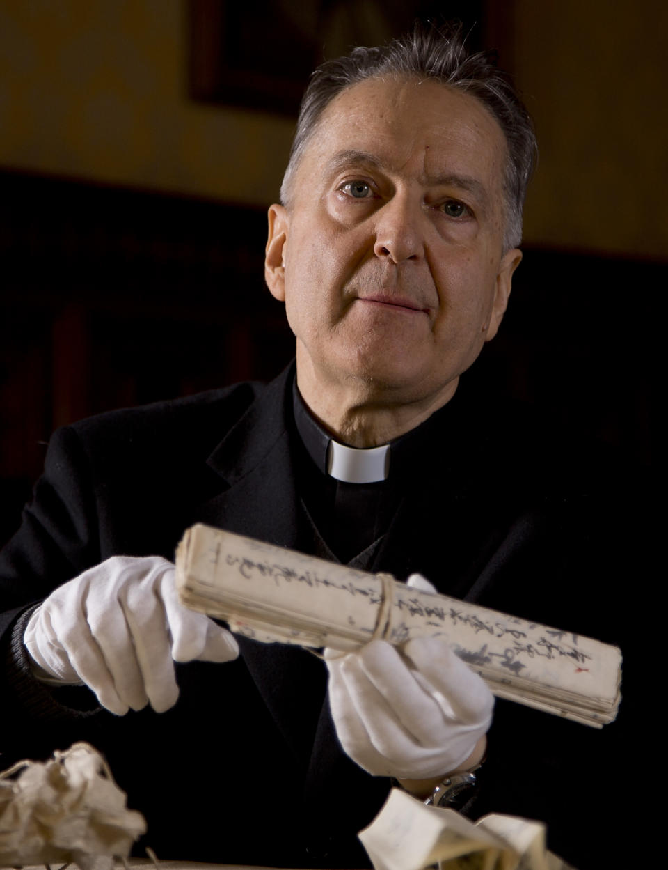 Prefect of the Vatican Apostolic Library Mons. Cesare Pasini shows Japanese manuscripts dating back to the 18th century recently found in the Vatican Library's archives during an interview with the Associated Press, at the Vatican Tuesday, Jan. 28, 2014. The Vatican library and four Japanese historical institutes have agreed to inventory, catalogue and digitize 10,000 documents from a lost Japanese archive detailing the crackdown on Christians in Japan in the 17th-19th centuries. Monsignor Cesare Pasini, head of the Vatican's Apostolic Library, said the so-called Marega Papers represent the largest known civic archive of its kind. An Italian missionary priest took the 22 bundles of documents out of Japan in the 1940s and brought them to Rome. They sat in the Vatican library's storage depository for decades until a Vatican researcher who could read the characters realized their importance in 2010. The six-year agreement signed Tuesday to inventory the documents and prepare them for study involves the National Institute of Japanese Literature and National Museum of Japanese History, among others. (AP Photo/Domenico Stinellis)