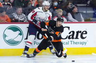 Philadelphia Flyers' Morgan Frost, right, battles for the puck against Washington Capitals' Anthony Mantha during the third period of an NHL hockey game, Wednesday, Dec. 7, 2022, in Philadelphia. (AP Photo/Matt Slocum)