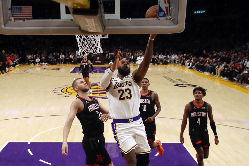 LOS ANGELES, CALIFORNIA - NOVEMBER 19: LeBron James #23 of the Los Angeles Lakers makes a layup against Jock Landale #2, Jabari Smith Jr. #10 and Jalen Green #4 of the Houston Rockets during the third quarter at Crypto.com Arena on November 19, 2023 in Los Angeles, California. NOTE TO USER: User expressly acknowledges and agrees that, by downloading and or using this photograph, User is consenting to the terms and conditions of the Getty Images License Agreement. (Photo by Katelyn Mulcahy/Getty Images)