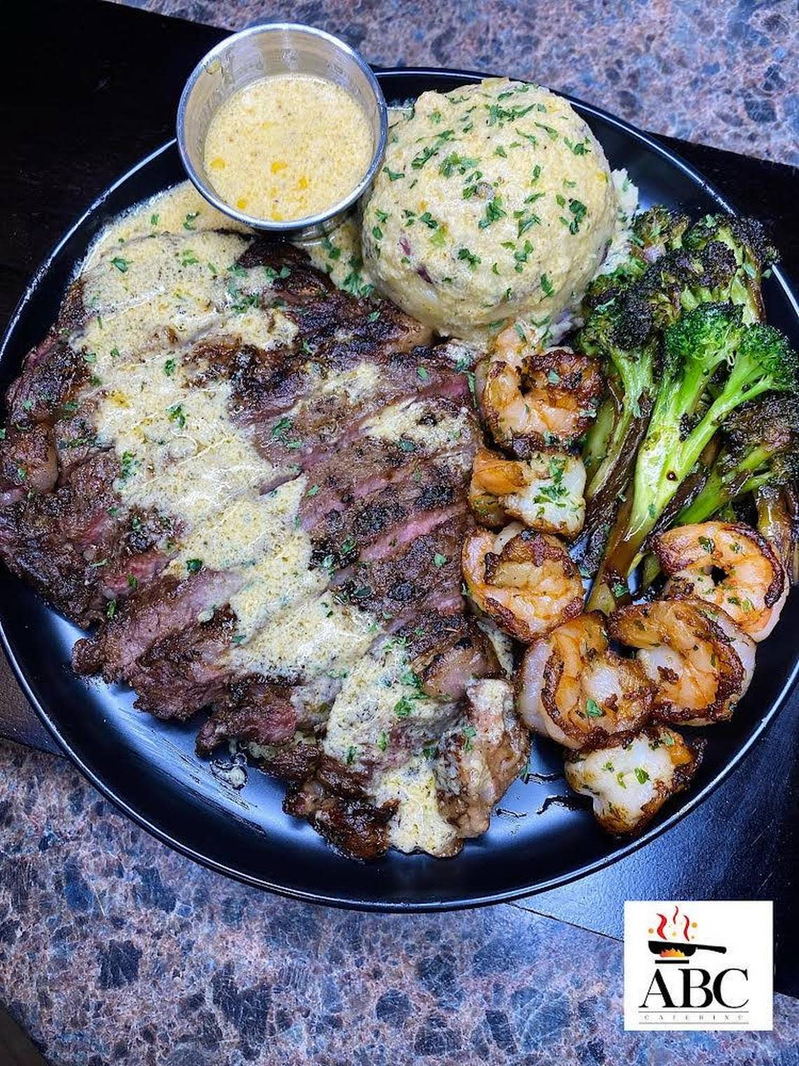 Boneless ribeye steak, sauteed shrimp, sauteed broccoli with garlic mashed potatoes finished with a special “love” sauce from ABC Catering LLC.