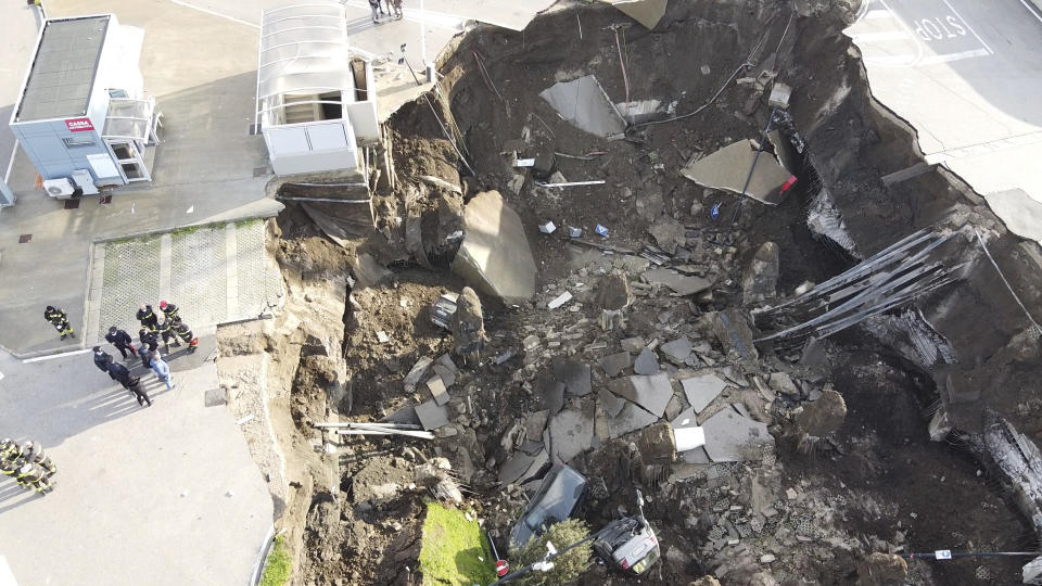 A view of the large sinkhole that opened overnight in the parking of Ospedale del Mare hospital in Naples, Italy, Friday, Jan. 8, 2021. A giant sinkhole opened Friday in the parking lot of a Naples hospital, forcing the temporary closure of a nearby residence for recovering coronavirus patients because the electricity was cut. (Alessandro Pone/LaPresse via AP)