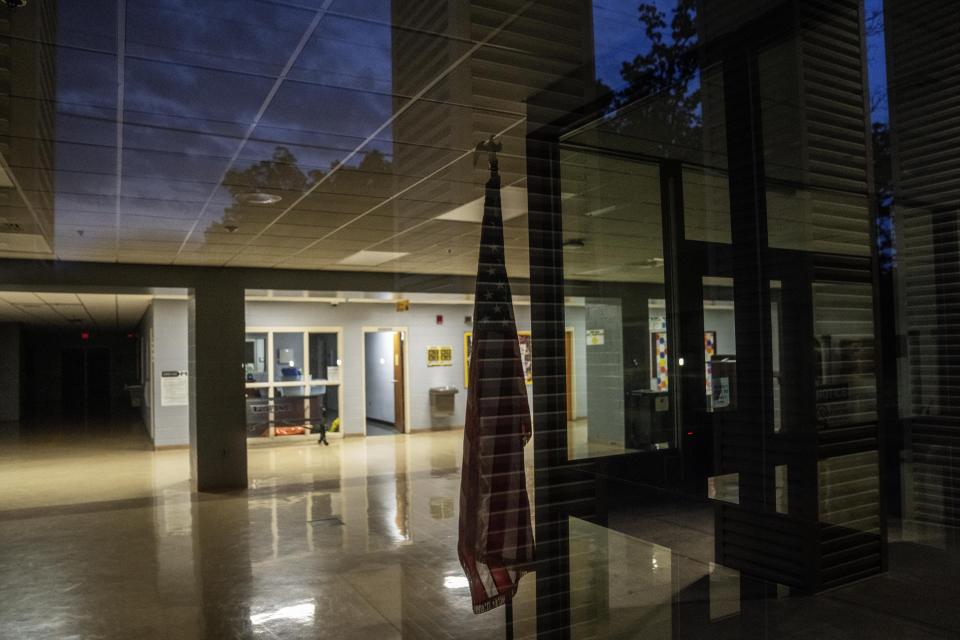 An American flag stands in the lobby of Heath High School in West Paducah, Ky., Sunday, June 4, 2023. In December 1997, a 14-year-old freshman walked into the lobby of the school with a .22-caliber pistol in his backpack and four long guns wrapped in blankets. Before the day’s first-period class began, he put plugs in his ears, drew the stolen handgun and started firing on a group of classmates gathered in a morning prayer circle. (AP Photo/David Goldman)