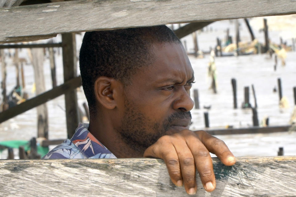 Stephen Tunlese, who lost his house and shop due to coastal erosion, stands inside damage stilt house looking at the sea in Ayetoro, Southwest Nigeria, Friday, April 5, 2024. Ayetoro, a coastal community more than 200 km southeast of Nigeria's business capital Lagos, has been experiencing coastal erosion for many years. But the changes have recently rapidly worsened with the community slumping into the Atlantic Ocean, leading to repeated displacements of households and businesses. (AP Photo/Dan Ikpoyi)