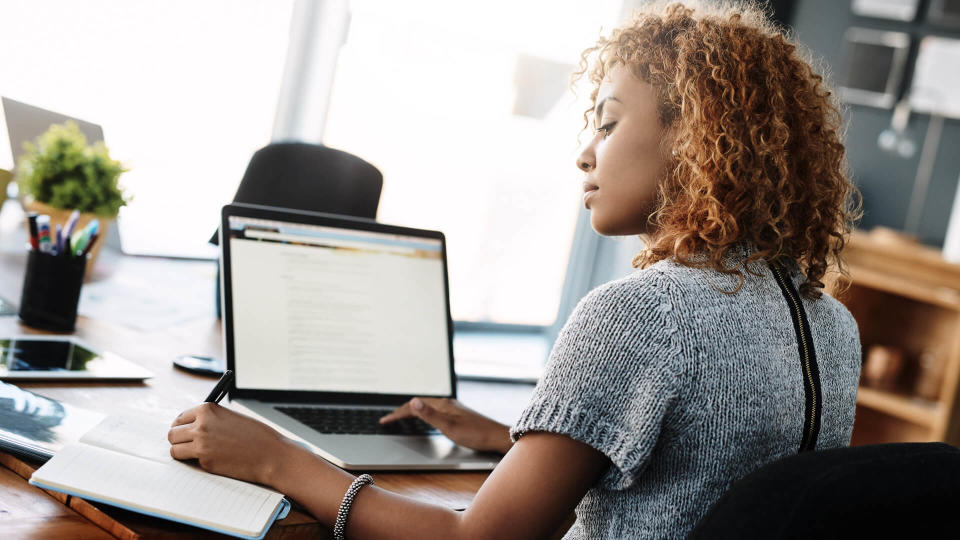 Shot of a young businesswoman working on a laptop in an office.