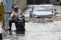 Commuter makes their way along a water-logged street following heavy rains in Amritsar on July 19, 2020. (Photo by NARINDER NANU / AFP) (Photo by NARINDER NANU/AFP via Getty Images)