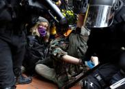 A counter-protester is detained by law enforcement after a Proud Boys rally in Portland, Oregon