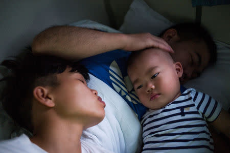 Huang Wensi and her husband travel for nearly a full day to bring their son back to their hometown where he will stay with his grandmother, in Lianjiang, Guangdong province, China, June 30, 2018. REUTERS/Yue Wu