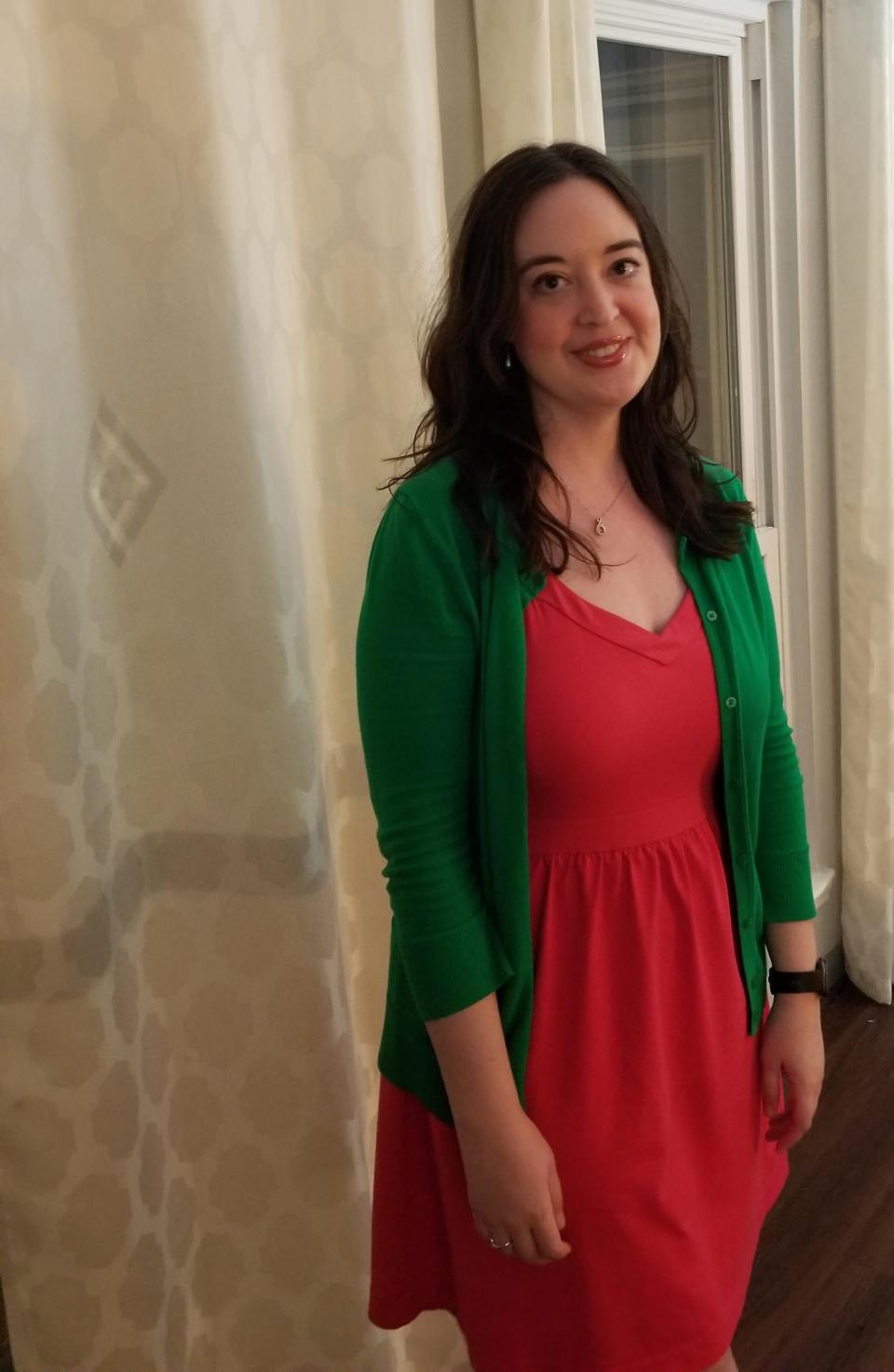 Meghan Bea wearing a red dress and green cardigan