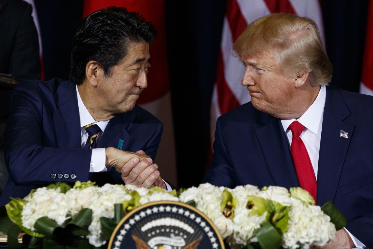 In this Sept. 25, 2019 photo, President Donald Trump shakes hands with Japanese Prime Minister Shinzo Abe before signing an agreement on trade at the InterContinental Barclay New York hotel during the United Nations General Assembly. 