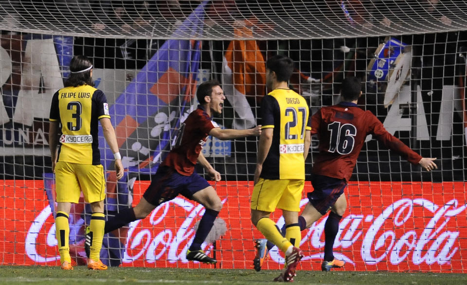 Osasuna's Roberto Torres, center, celebrates his goal and the third of his team after scoring against Atletico de Madrid, during their Spanish League soccer match, at El Sadar stadium in Pamplona, Spain, Sunday, Feb. 23, 2014. (AP Photo/Alvaro Barrientos)