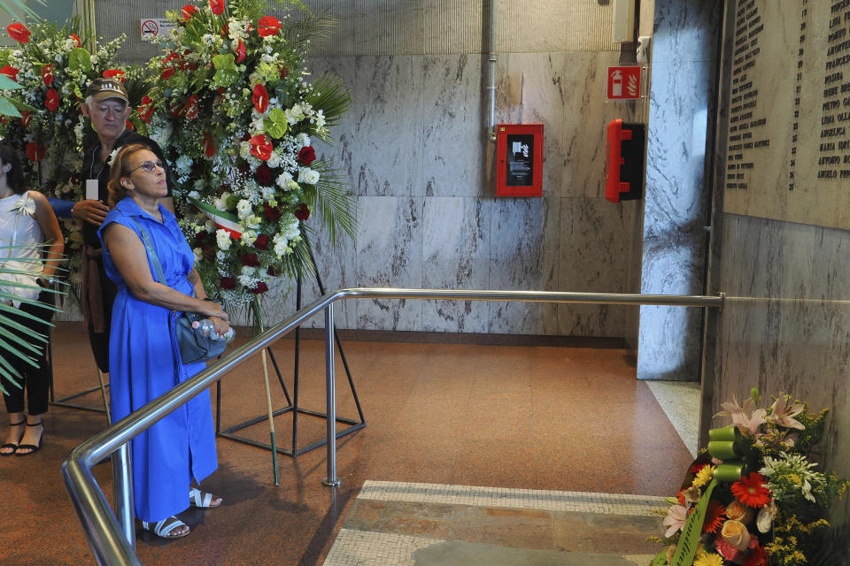 A woman looks at the Bologna bombing memorial plaque bearing the names of the 85 victims on the 43rd anniversary of the 1980 train station bombing in this central Italian city, Wednesday, Aug. 2, 2023. When Giorgia Meloni was running to become Italy’s first far-right head of government since the demise of the country's fascist dictatorship, she steeped her campaign in ideological touchpoints like national sovereignty and “traditional families.” (Michele Nucci LaPresse Via AP)