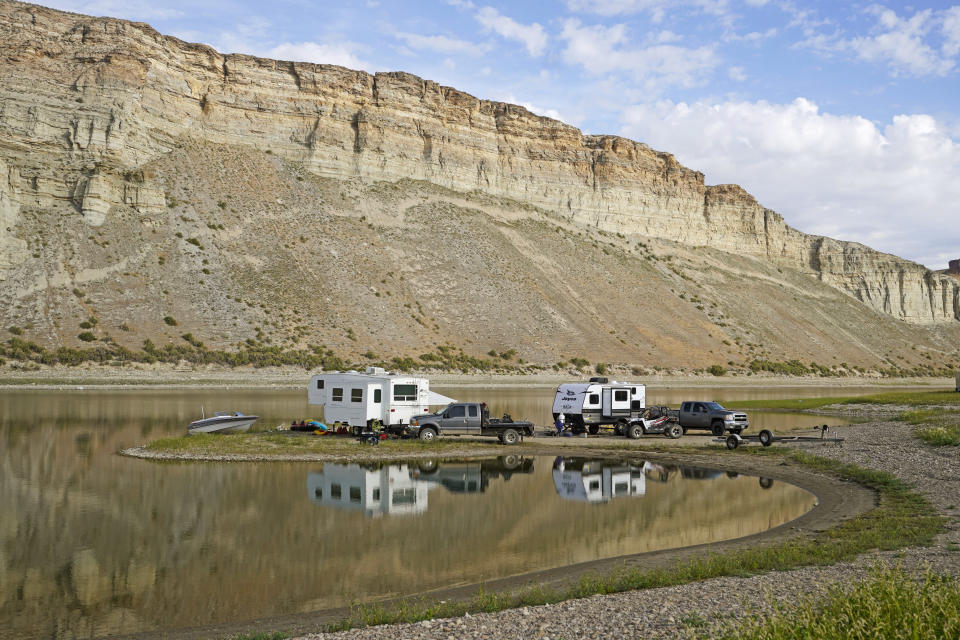 Campers are parked along the receding edge of Flaming Gorge Reservoir on Firehole Canyon on Friday, Aug. 5, 2022, in Wyoming (AP Photo/Rick Bowmer)