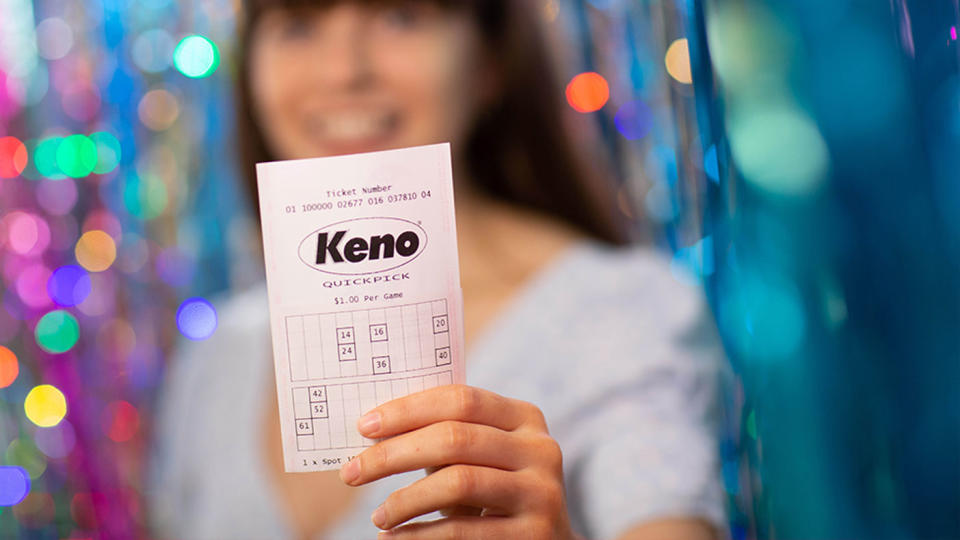 A woman holding a Keno Quickpick ticket. Source: The Lott