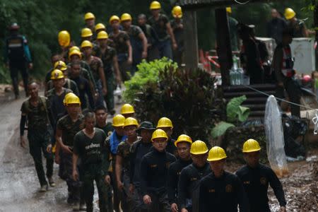 Military personnel walk in line as they prepare to enter the Tham Luang cave complex, where 12 boys and their soccer coach are trapped, in the northern province of Chiang Rai, Thailand, July 6, 2018. REUTERS/Athit Perawongmetha