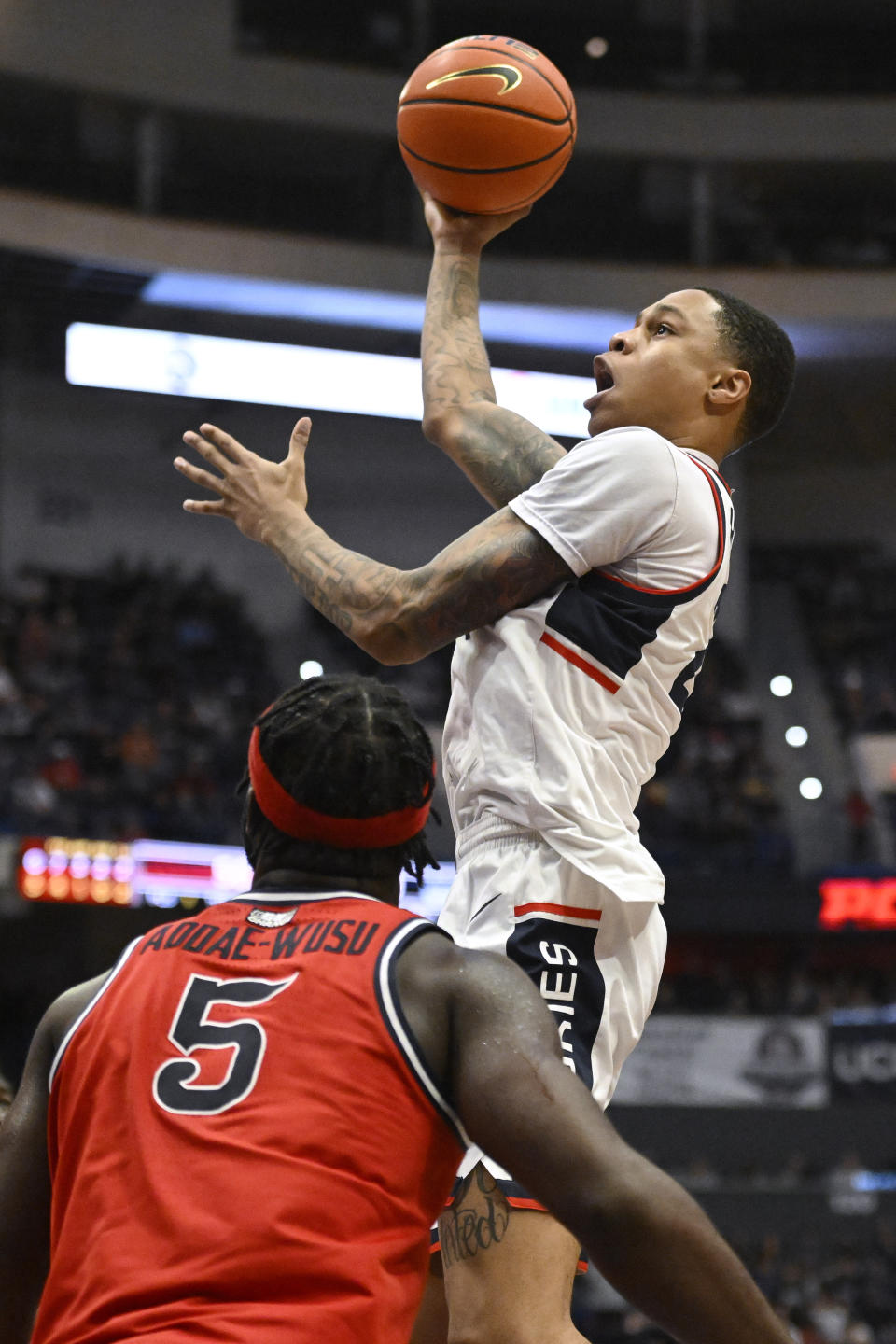 UConn's Jordan Hawkins shoots over St. John's Dylan Addae-Wusu (5) in the second half of an NCAA college basketball game, Sunday, Jan. 15, 2023, in Hartford, Conn. (AP Photo/Jessica Hill)