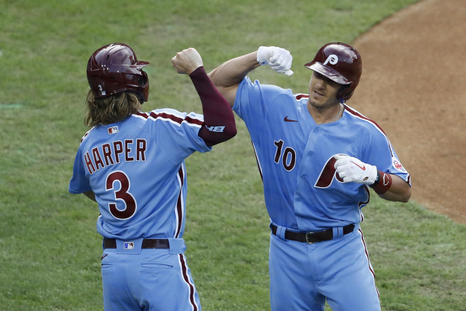 Philadelphia Phillies' J.T. Realmuto, right, and Bryce Harper celebrate after Realmuto's three-run home run off New York Yankees starting pitcher Jordan Montgomery during the first inning of a baseball game Thursday, Aug. 6, 2020, in Philadelphia. (AP Photo/Matt Slocum)