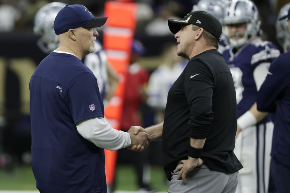 Dallas Cowboys acting head coach Dan Quinn, left, speaks with New Orleans Saints head coach Sean Payton before the first half of an NFL football game, Thursday, Dec. 2, 2021, in New Orleans. (AP Photo/Derick Hingle)