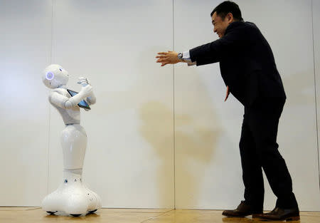 Board Director of Product Division for SoftBank Robotics Kazutaka Hasumi (R) performs with SoftBank's emotion-reading robot Pepper during a demonstration with the robot, to show its compatibility with Google's Android software, at the company's headquarters in Tokyo, Japan, May 19, 2016. REUTERS/Toru Hanai