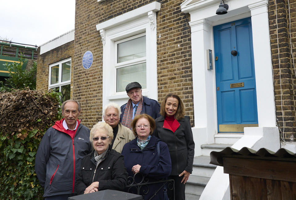 In this Sept. 30, 2021 photo provided by English Heritage family members of African American freedom fighters Ellen and William Craft pose for a photo outside a house where they settled and raised their family, in Hammersmith, London. English Heritage on Tuesday, Oct. 5, 2021 marked the accomplishments of Ellen and William Craft with a blue plaque outside the two-story brick row house in the Hammersmith area of West London from which they campaigned for the end of slavery. The couple escaped slavery in 1848 when Ellen, the light-skinned daughter of a Black woman raped by her enslaver, disguised herself as a disabled white man traveling north for medical treatment. William accompanied her, posing as her servant. (Justin Thomas/English Heritage via AP)