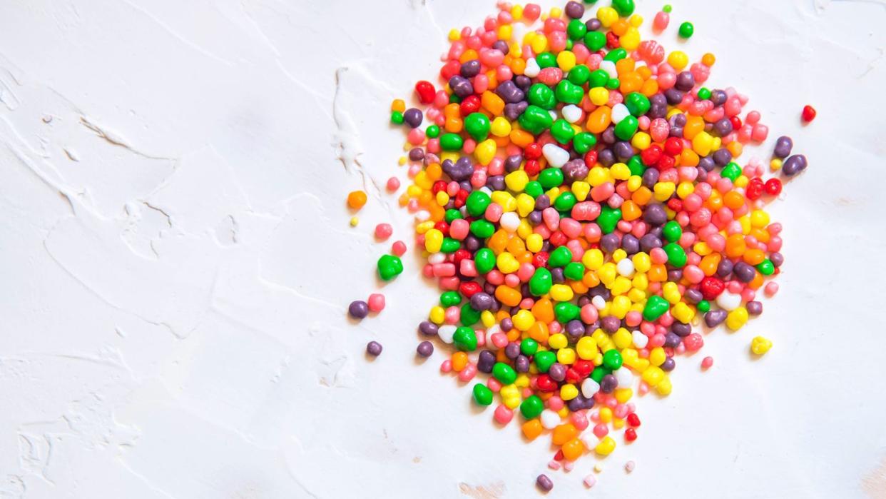 rainbow colored candy nerds sprinkled on a white background