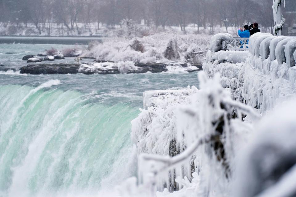 TOPSHOT - Two men take photographs at the Horseshoe Falls in Niagara Falls, Ontario, on January 27, 2021. (Photo by Geoff Robins / AFP) (Photo by GEOFF ROBINS/AFP via Getty Images)