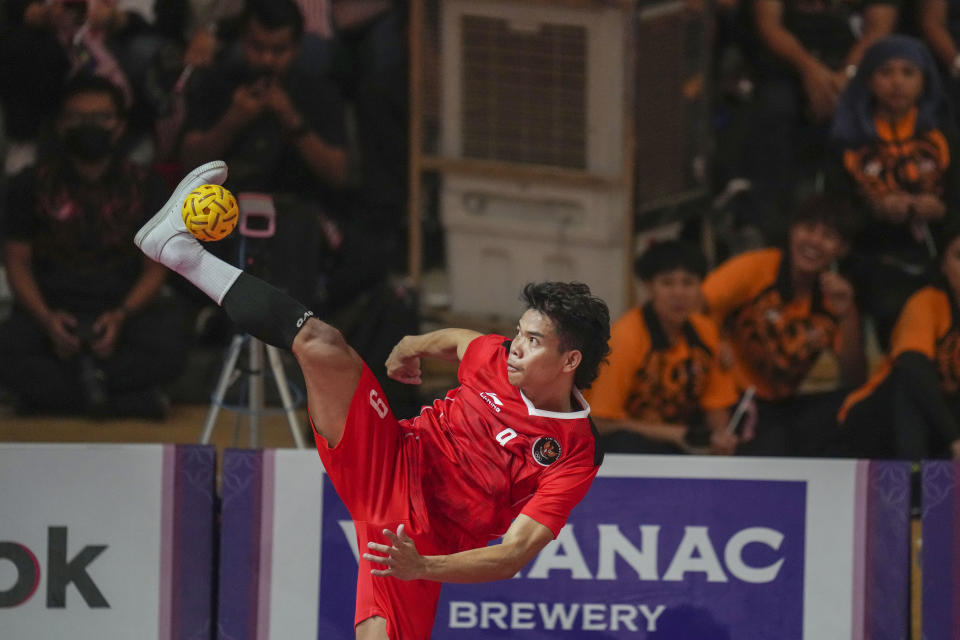 Indonesia's Rusdi Rusdi kicks a ball against Malaysia's during men's team doubles sepaktakraw final match at the 32nd Southeast Asian Games in Phnom Penh, Cambodia, Monday, May 15, 2023. (AP Photo/Tatan Syuflana)