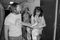 <p>Led Zeppelin's Jimmy Page and Robert Plant chat with a fan as they walk backstage at Madison Square Garden after a concert in 1977. </p>