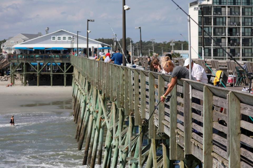 Crowds fish off the side of the Garden City Pier. Myrtle Beach area piers took a battering from Hurricane Ian this year but a strong pier culture prevails drawing fisherman and tourist back year after year. October 10, 2022.