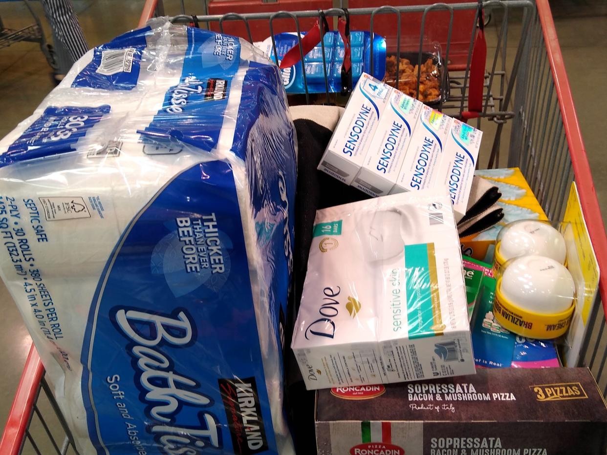 Orange costco cart filled with products like toilet paper and bar soap