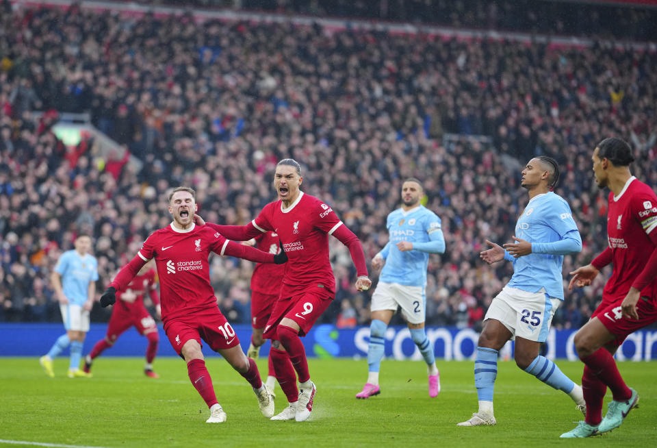Liverpool's Alexis Mac Allister, left, celebrates after scoring a penalty, his side's first goal during the English Premier League soccer match between Liverpool and Manchester City, at Anfield stadium in Liverpool, England, Sunday, March 10, 2024. (AP Photo/Jon Super)