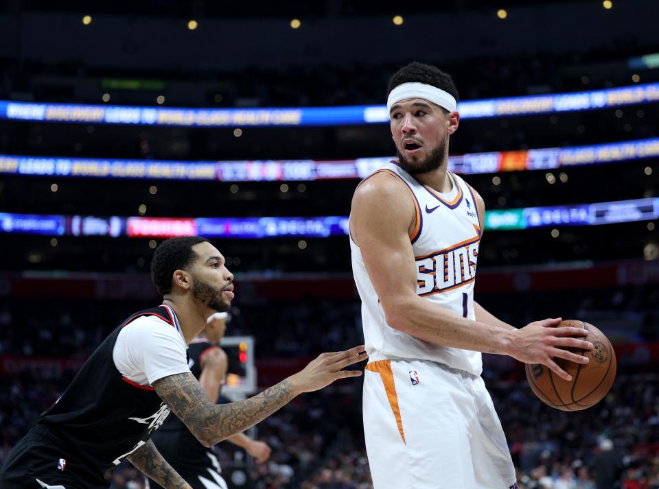 Devin Booker #1 of the Phoenix Suns posts up Xavier Moon #22 of the LA Clippers during a 124-108 Suns win at Crypto.com Arena on April 10, 2024 in Los Angeles, California.