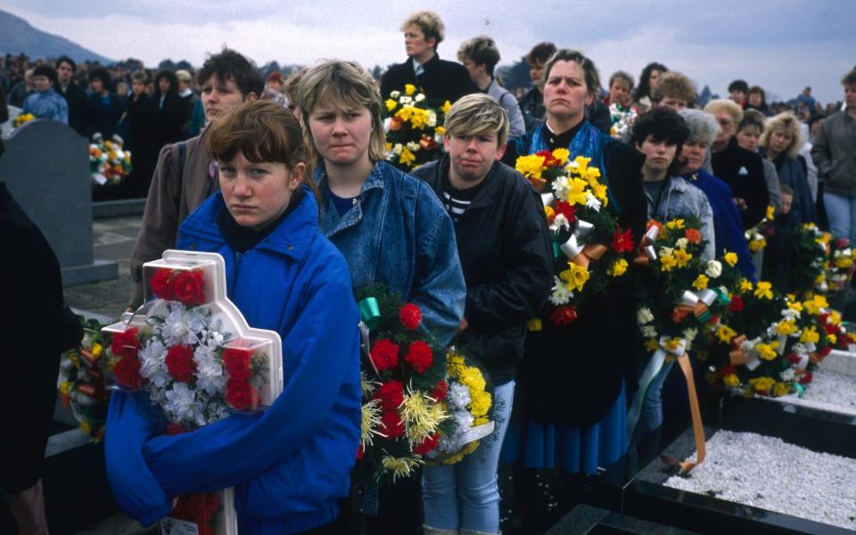 Mourners stand in a cemetery during the funeral for three IRA members killed on Gibraltar. - Sygma