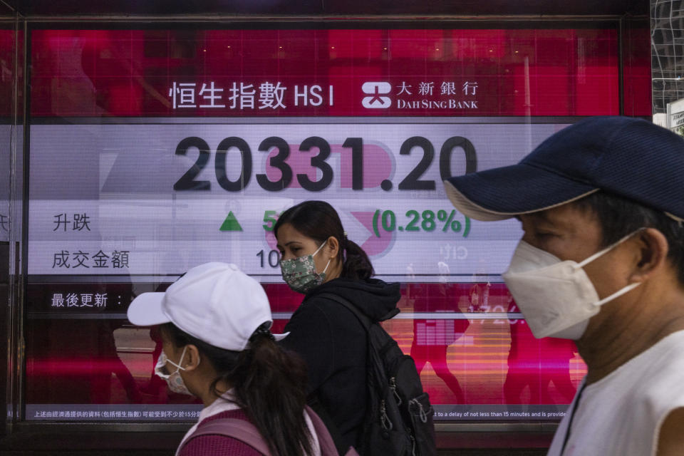 Pedestrians walk past the Dah Sing Bank's electronic screen in Hong Kong, Friday, April 7, 2023. The figures displayed on the screen are from Thursday. Asian stock markets followed Wall Street higher on Friday ahead of a U.S. job market update that traders hope might encourage the Federal Reserve to ease off plans for more interest rate hikes. (AP Photo/Louise Delmotte)
