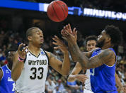Wofford's Cameron Jackson (33) and Seton Hall's Myles Powell, right, go after a loose ball during the first half of a first-round game in the NCAA men’s college basketball tournament in Jacksonville, Fla., Thursday, March 21, 2019. (AP Photo/Stephen B. Morton)