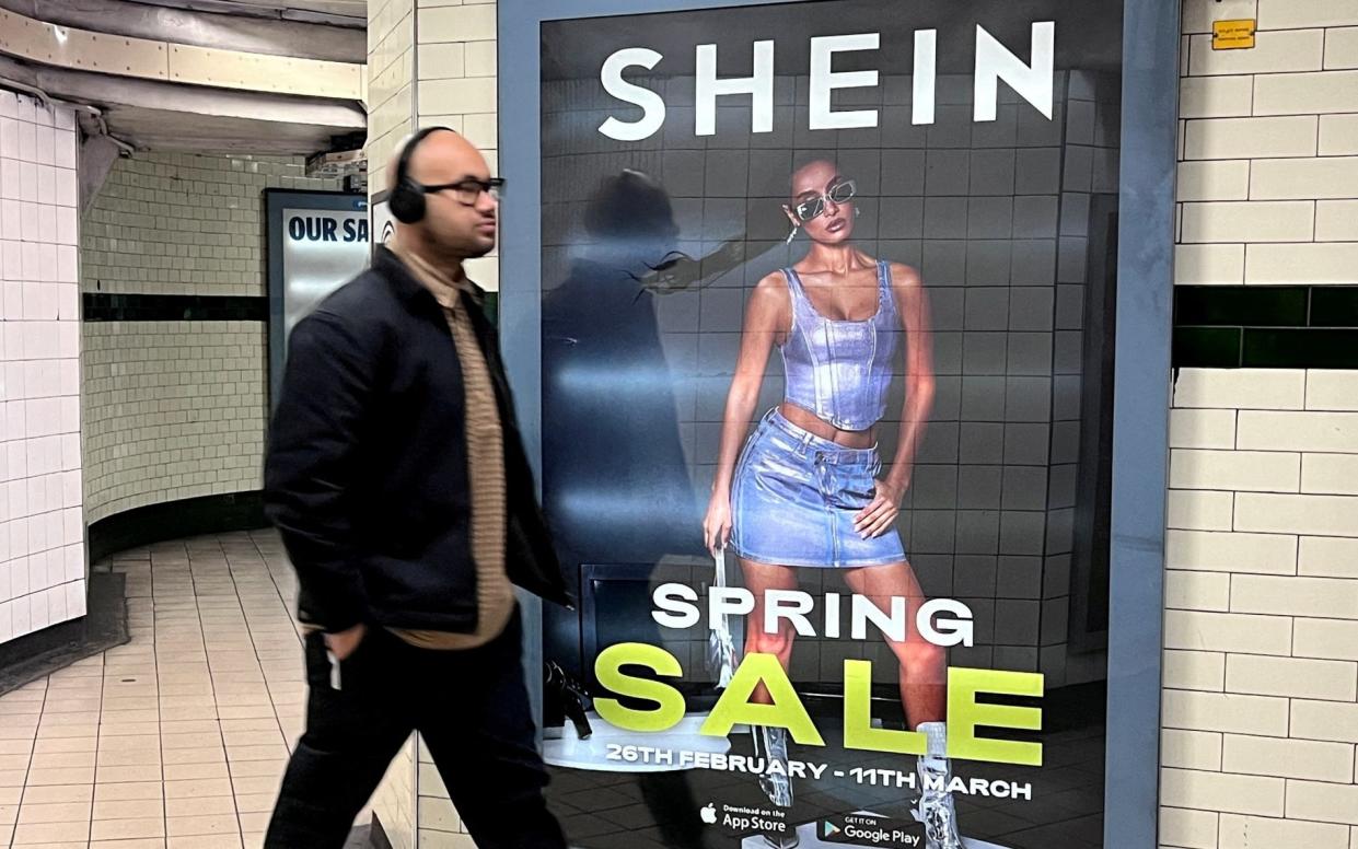 A commuter passing a Shein advert in London