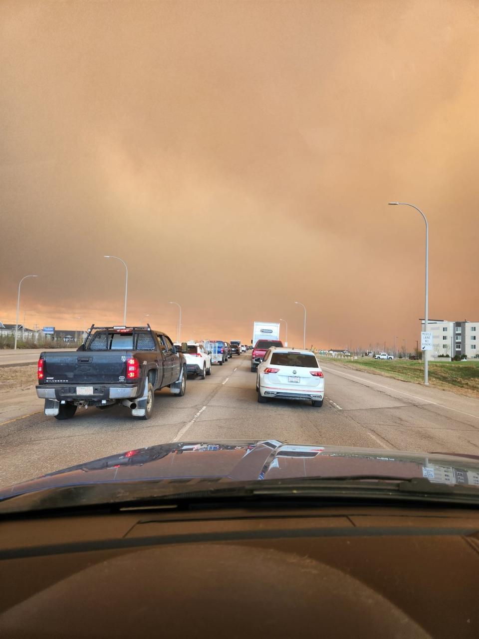 Cars line up on the highway in Fort McMurray. Four neighbourhoods in Fort McMurray, Alta. were ordered to evacuate earlier this week as a wildfire threatened parts of the city. 