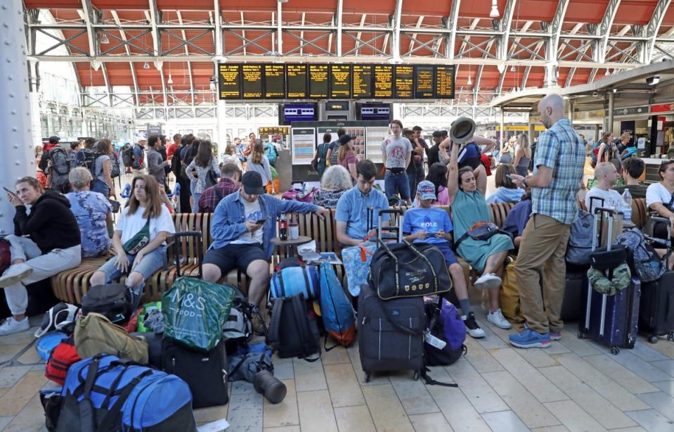 Passengers bound for the Glastonbury Festival wait at Paddington station in London (Ashlee Ruggels/PA) (PA Wire)