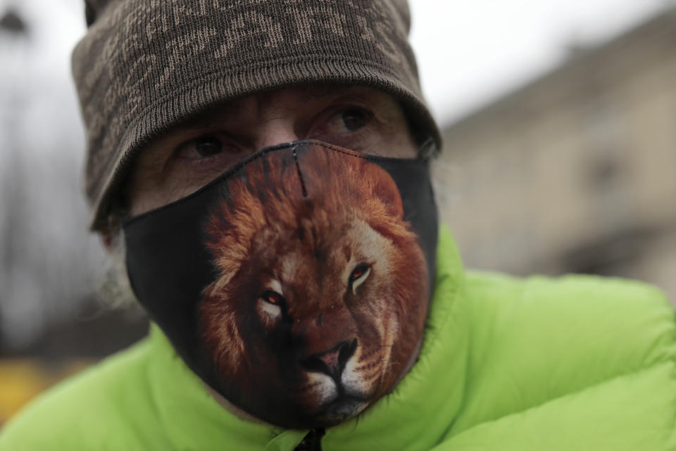 Frederic Edelstein, an animal trainer for the Pinder Circus, wears a mask printed with a lion during a protest Tuesday, Jan.26, 2021. French lawmakers start debating Tuesday a bill that would ban using wild animals in traveling circuses and keeping dolphins and whales in captivity in marine parks, amid other measures to better protect animal welfare. Circus workers stage a protest outside the National Assembly to denounce what they consider "a mistake." (AP Photo/Lewis Joly)