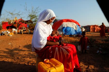 Zeinab, 14, sits as she holds her nephew at a camp for internally displaced people from drought hit areas in Dollow, Somalia April 4, 2017. REUTERS/Zohra Bensemra