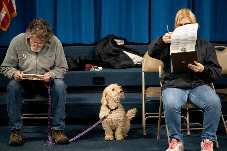 Jeff Seiter, left, and his daughter Nina, 26, right, along with their dog Jem opted to vote a paper ballot to get through the line faster. Voters waited in line around 40 minuets to cast their vote this morning in Clintonville. The OCALI Glenmont School polling location only had six ballot booths.