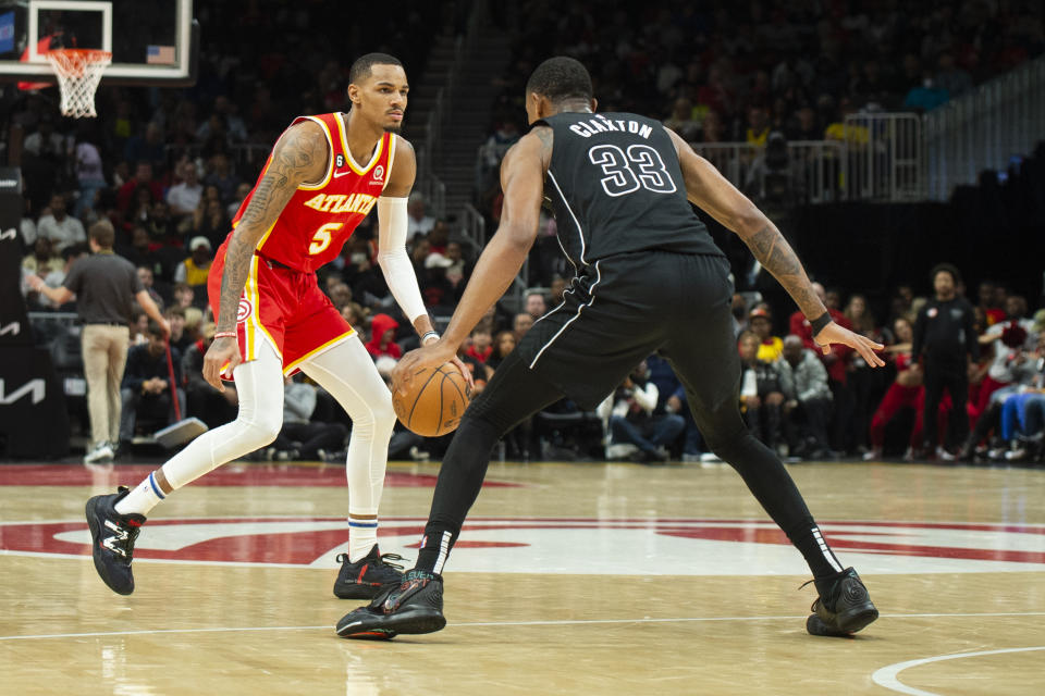 Atlanta Hawks guard Dejounte Murray, left, dribbles against Brooklyn Nets center Nic Claxton during the first half of an NBA basketball game, Sunday, Feb. 26, 2023, in Atlanta. (AP Photo/Hakim Wright Sr.)